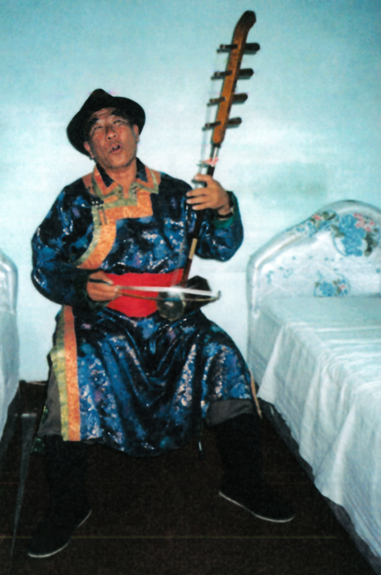 photo of the Mongolian bard Nimaodzer, singing and playing his instrument (a four-stringed fiddle) in his home in the 1980s or 1990s